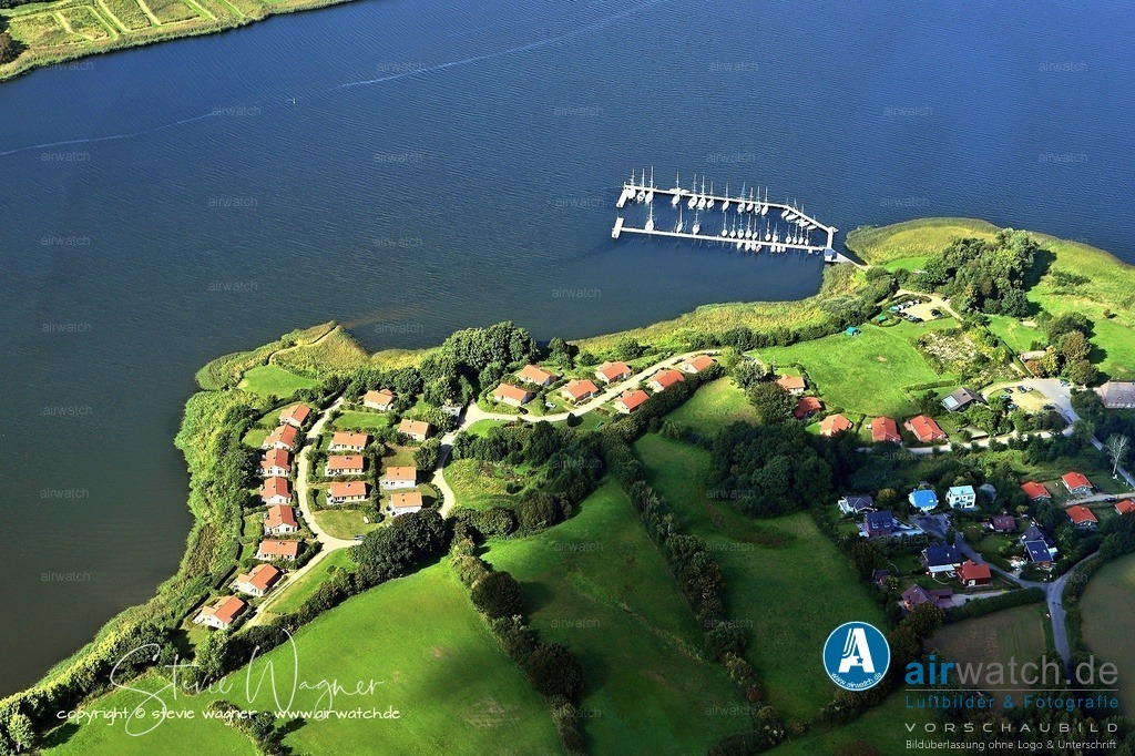 Luftbild Ostseefjord Schlei, Bohnert, Marina Huelsen, Sportboothafen | Bohnert-Hülsen ist ein Ortsteil der Gemeinde Kosel in Schleswig-Holstein, direkt am Südufer der Schlei gelegen. Er umfasst den idyllischen Hof Hülsen, der sowohl einen Campingplatz als auch die Marina Hülsen mit Ferienhäusern und einem Hafencafé beherbergt. Die Region ist bekannt für ihre naturnahe Lage, ideale Bedingungen für Wassersport und erholsame Urlaubsmöglichkeiten direkt am Wasser.