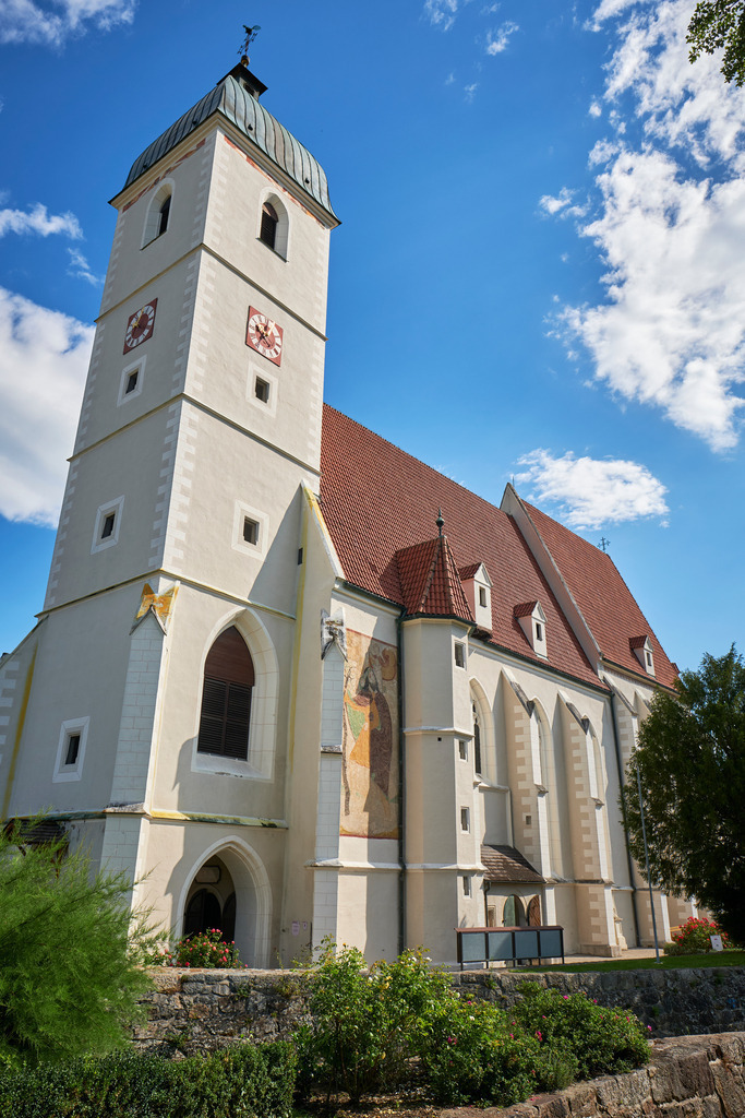 Pfarrkirche in Kirchschlag mit Rosengarten | Kirchschlag, Austria - August 19, 2020: Pfarrkirche in Kirchschlag mit Rosengarten. - Realisiert mit Pictrs.com