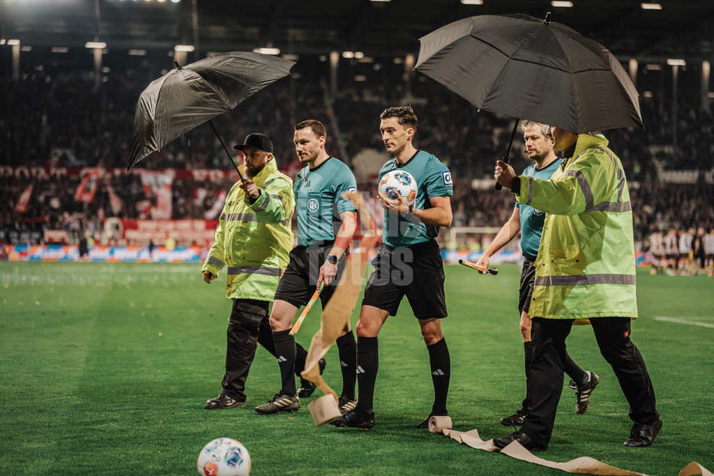 Fußball | Männer | Saison 2025/2026  | Fußball-Bundesliga | 27. Spieltag | FC St. Pauli vs. SC Freiburg | 22.04.2026 | Klopapiert wird auf die Schiedsrichter v.l. Philipp Hüwe, Florian Brandstübner und Markus Schüller geworfen Regenschirm Eskort aus dem Stadion heraus