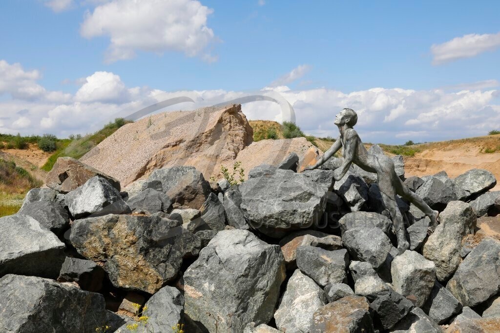 NatureArt-BLACKSTONES_2849c | Graues Fotomodell steht zwischen Steinen | #002 | Modell: Renée-Claire | Foto: Tschiponnique Skupin - Realisiert mit Pictrs.com