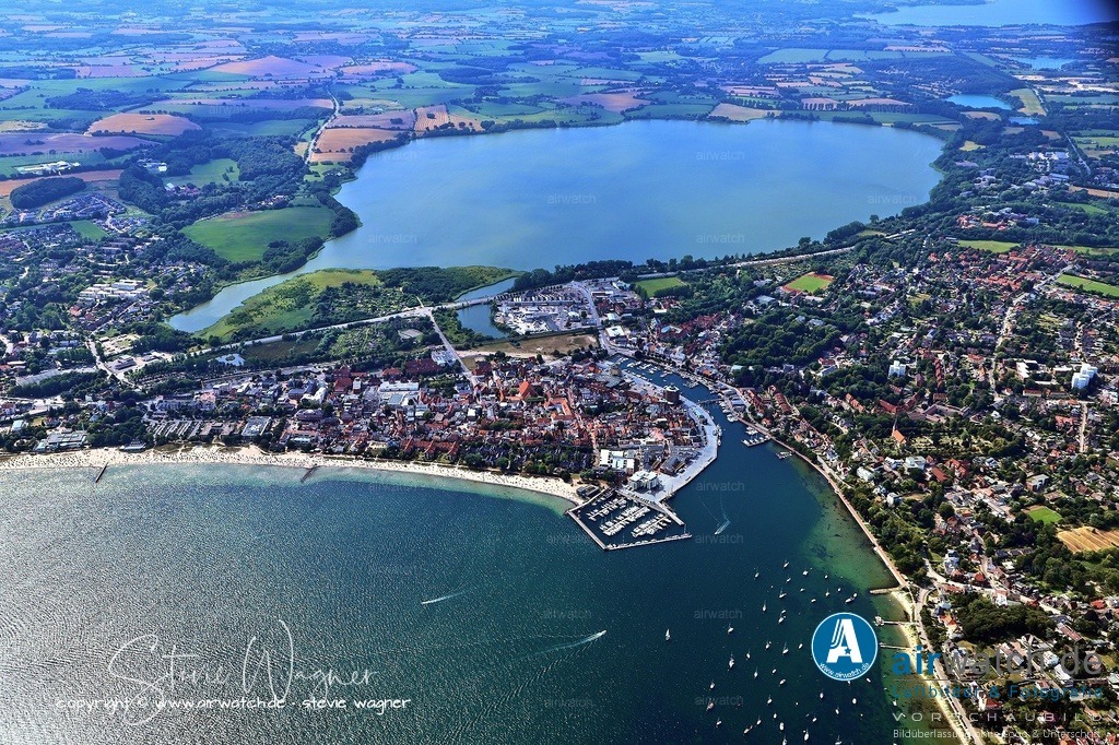 Luftbild Eckernförde - Die militärische Präsenz begann 1912 mit der Errichtung des Schießstandes für die kaiserliche Torpedowerkstatt in Friedrichsort | Die militärische Präsenz begann 1912 mit der Errichtung des Schießstandes für die kaiserliche Torpedowerkstatt in Friedrichsort, und 1936 bezog die Marine die Anlagen in Carlshöhe, die bei Kriegsende rund 7.000 Beschäftigte umfasste. Nach 1945 siedelten sich über 10.000 Kriegsflüchtlinge in der fast unzerstörten Stadt an, was zu einem sprunghaften Bevölkerungszuwachs führte.