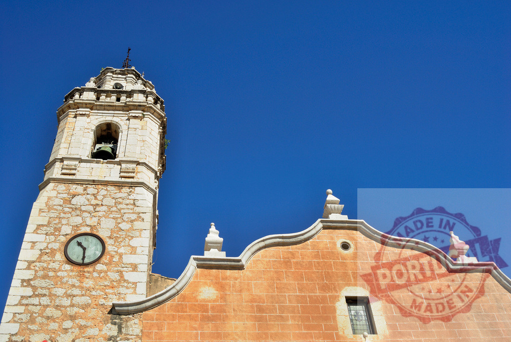 Sant Bartomeu i Santa Tecla church bell tower in Sitges | Historic church architecture and clock tower under a clear blue sky in Sitges, Spain - Realized with Pictrs.com