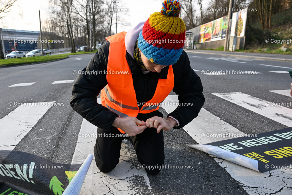  Klimagegner Linz Waldeggstrasse_ Klimakleber_ 20.03.2023-25 | 20.03.2023, Linz, AUT, Klimagegner Linz Klimakleber, im Bild Klimagegner kleben auf der Strasse, Linz Waldeggstrasse, Polizei, Verkehr, Zebrastreifen, Fussgaengeruebergang, Transparent, Demo, Klimawandel