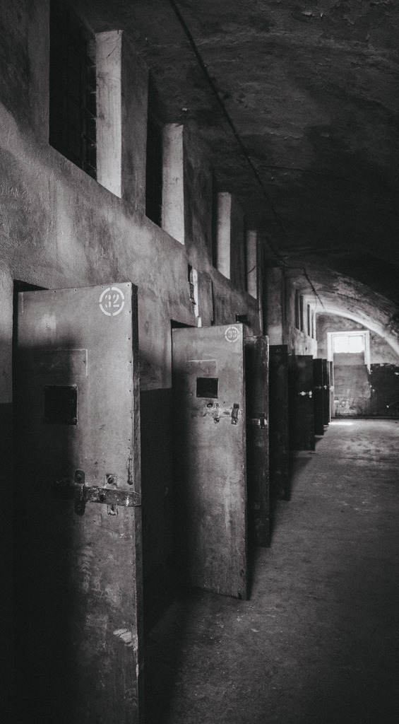 Abandoned Prison Corridor – Dark Industrial Architecture Photography | A quiet corridor of a former prison, where light and shadow reveal the traces of forgotten stories etched into concrete and steel. - Realisiert mit Pictrs.com