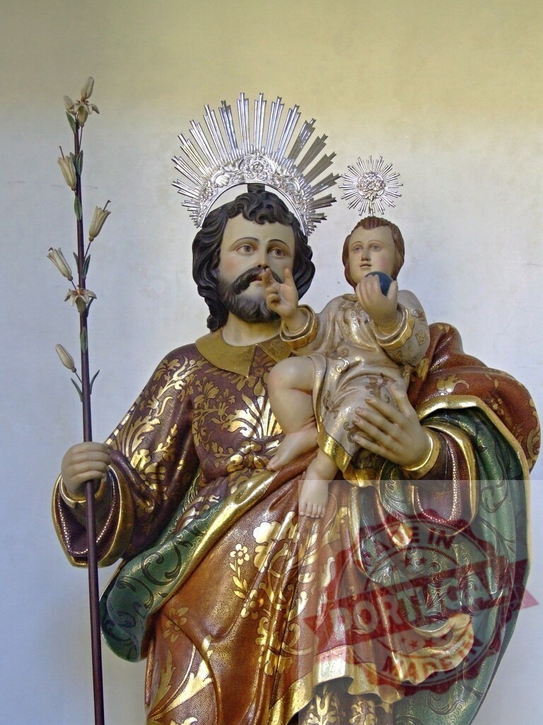 Saint Joseph holding baby Jesus with silver halo and lily flower | Wooden statue of Saint Joseph holding baby Jesus, with silver halo and lily flower, representing purity and innocence - Realisiert mit Pictrs.com