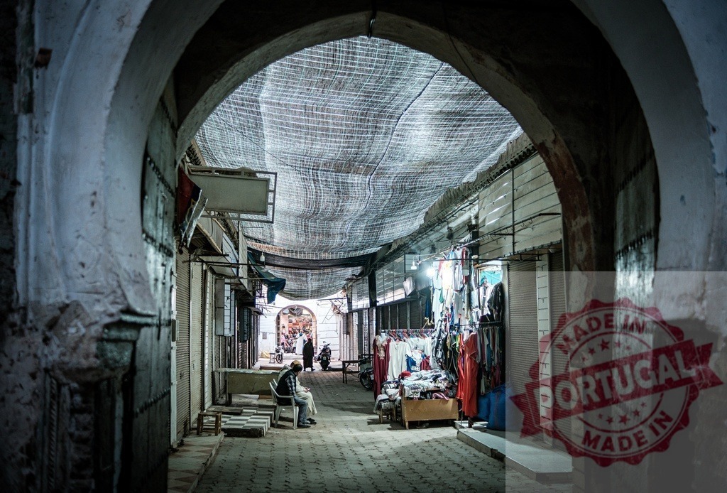 Vendor waiting for customers in the deserted alley of the medina of Fes | Vendor sitting in the deserted alley of the medina of Fes, Morocco, waiting for customers - Realisiert mit Pictrs.com