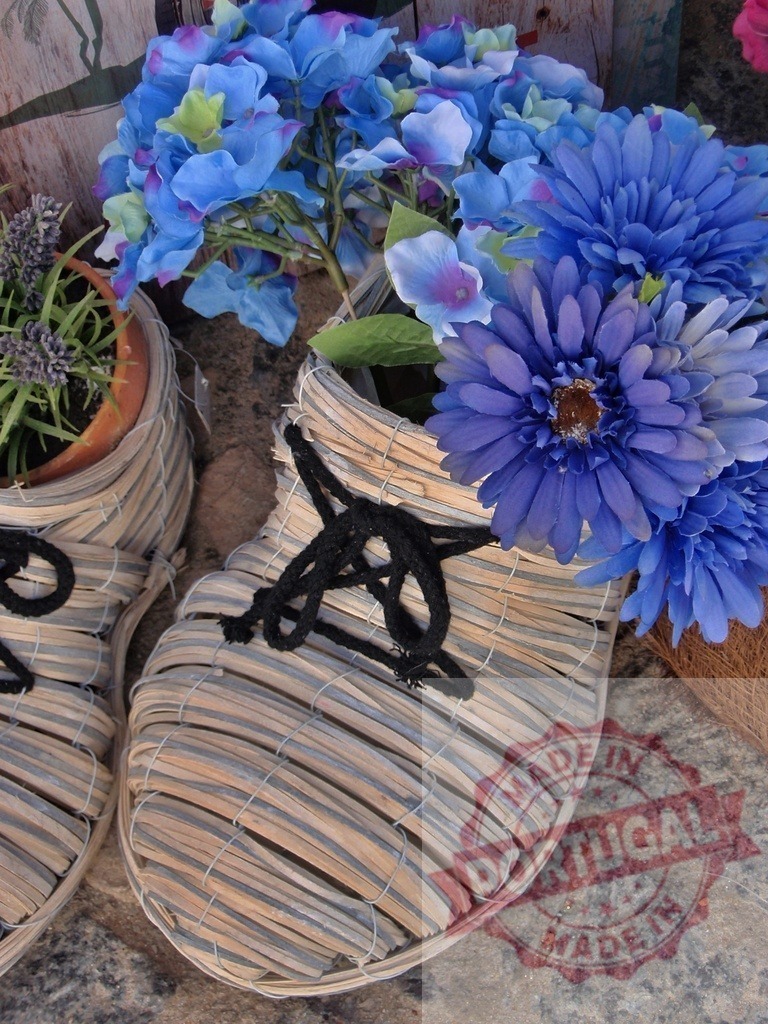 Wicker clogs holding blue and purple flowers | Wicker clogs serving as planters holding blue and purple artificial flowers and lavender - Realized with Pictrs.com