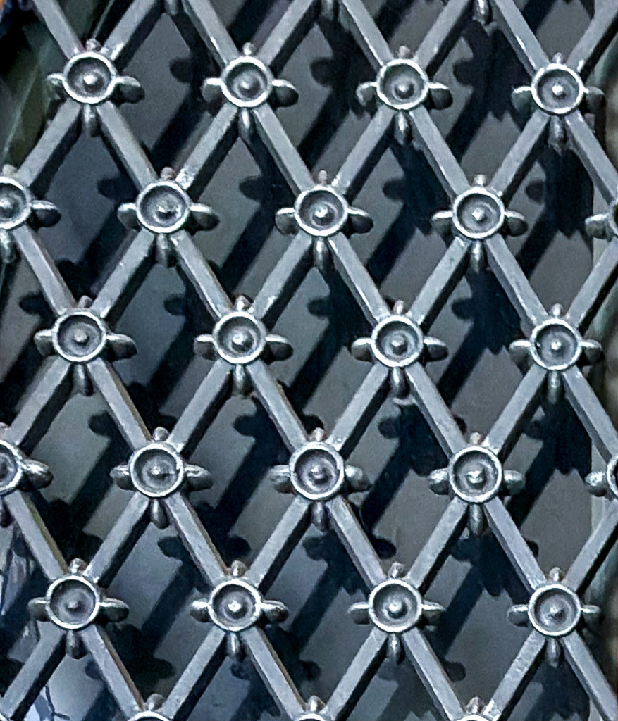 Geometrisches Wabengitter | Abstrakte Architektur Fotokunst | Edle Schwarz-Weiß-Fotokunst mit hypnotischer Wirkung. Diese abstrakte Nahaufnahme einer geometrischen Fassadenstruktur fasziniert durch ihr rautenförmiges Wabengitter und das präzise Spiel aus Licht und Schatten. Als großformatiges Wandbild (besonders ausdrucksstark auf mattem Alu-Dibond oder als tiefenwirksamer Gallery-Print) bringt dieses minimalistische Kunstwerk moderne Eleganz in jedes Wohnzimmer, Loft oder Büro. - Realisiert mit Pictrs.com