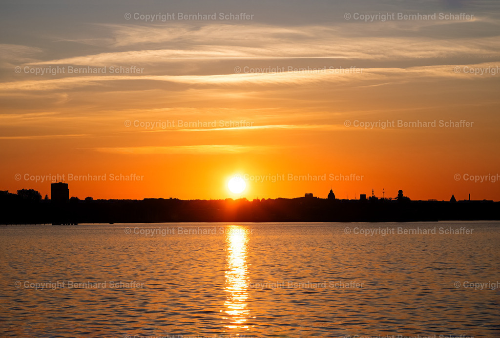 Sonnenuntergang an der Kieler Förde | Ein Sonnenuntergang an der Kieler Förde an der Ostsee mit Häusersilhouetten am Horizont.  - Realisiert mit Pictrs.com