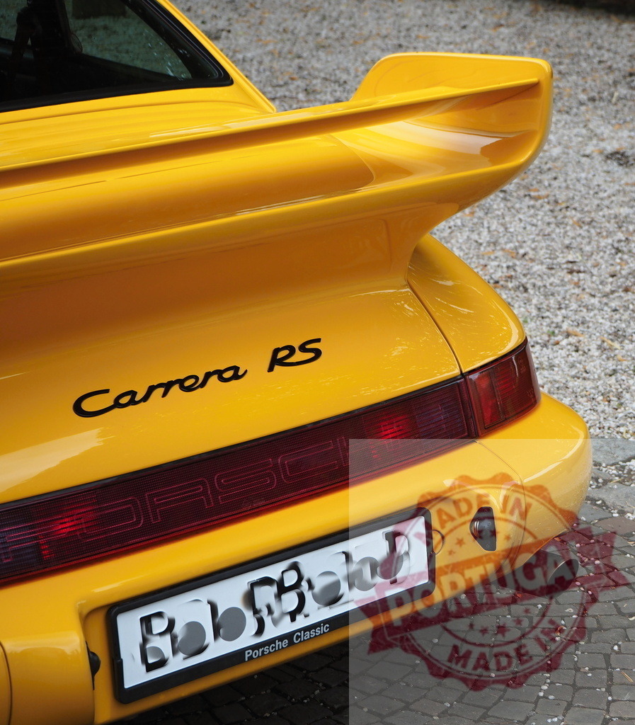 Porsche 911 Carrera RS yellow sports car rear view | Yellow Porsche 911 Carrera RS showing large rear spoiler and badge - Realized with Pictrs.com