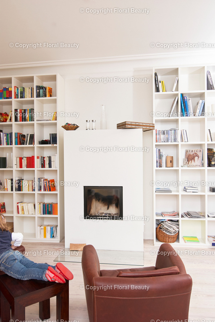 Kaminzimmer | brauner Ledersessel vor Kamin und Bücherregalen - Realisiert mit Pictrs.com