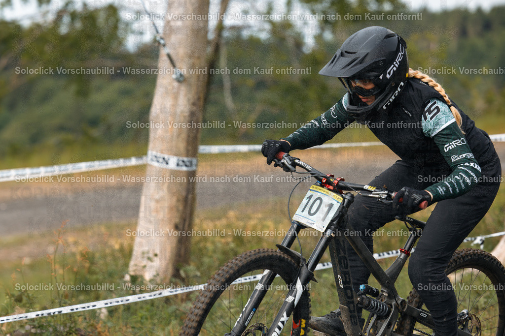 Action im Bikepark Winterberg: iXS Downhill Cup 2025 | Das Foto zeigt einen Mountainbiker während des iXS Downhill Cups 2025 im Bikepark Winterberg, speziell auf der Strecke 'The Mother'. Der Fahrer ist in voller Downhill-Ausrüstung, inklusive schwarzem Helm und schwarzen Handschuhen, sowie einer schwarzen Jacke und Hose mit dem Giro-Logo, zu sehen. Er fährt ein Downhill-Mountainbike mit roten Bremsscheiben und einer auffälligen Gabel. Im Hintergrund ist die Strecke mit Bandabgrenzungen und Bäume zu sehen. - Realisiert mit Pictrs.com