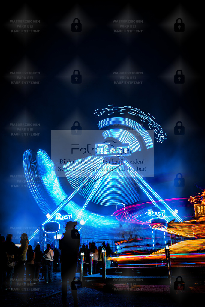 Lichterrausch auf der Kirmes | Leuchtende Farben, Bewegung und Energie – dieses Bild fängt das pulsierende Leben einer Kirmesnacht ein.Das Fahrgeschäft „The Beast“ hinterlässt mit seinen Lichtspuren ein beeindruckendes Muster aus Blau und Magenta – ein Sinnbild für Adrenalin, Spaß und unbeschwerte Momente. - Realisiert mit Pictrs.com