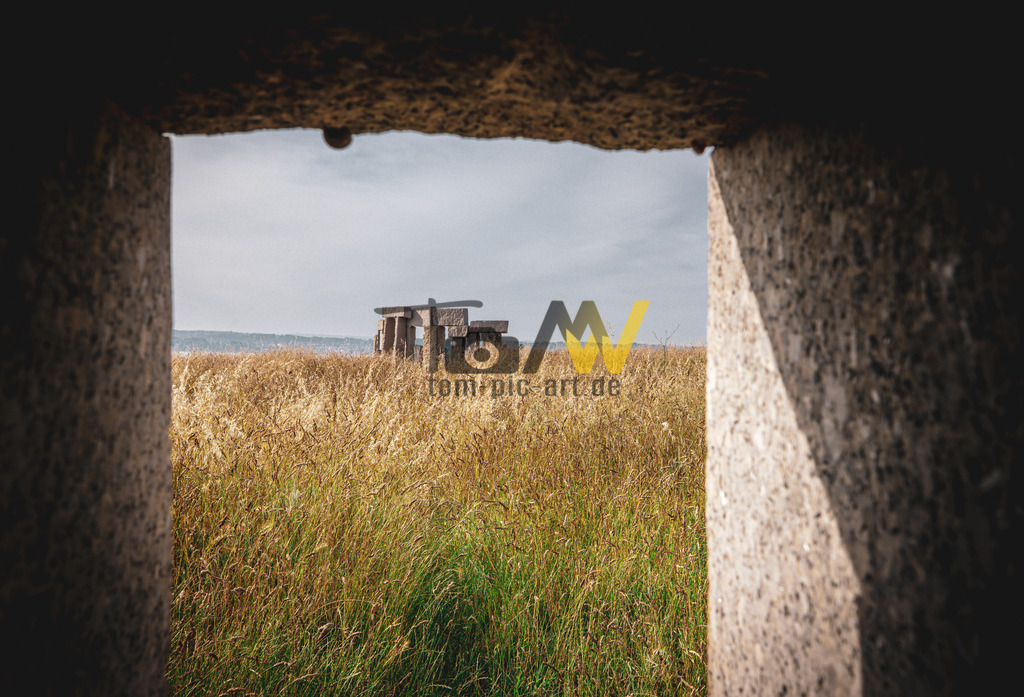 Die Skulpturen Menhires por la Paz am Herkules Turm-A Coruña | Das Bild zeigt einen Blick auf die Skulpturengruppe "Menhires por la Paz" (Menhire für den Frieden) des Künstlers Manolo Paz in A Coruña, Galicien, Spanien. Über die SkulpturStandort: Die Installation befindet sich im Skulpturenpark rund um den Herkules-Turm (Torre de Hércules) in A Coruña.Künstler: Erschaffen wurde sie von dem galicischen Bildhauer Manolo Paz im Jahr 1994.Beschreibung: Es handelt sich um eine Gruppe von zwölf großen Steinskulpturen (Menhiren), die in einem Kreis angeordnet sind und die Himmelsrichtungen markieren.Besonderheit: Jeder Menhir hat ein Fenster oder eine Öffnung, die einen besonderen Blick auf die Umgebung und das Meer bietet, wodurch die Skulpturen in einen Dialog mit dem Ort treten.Konzept: Die Skulpturengruppe gilt als "Galicisches Stonehenge" und symbolisiert eine Botschaft des Friedens und der Einheit.  - Realisiert mit Pictrs.com