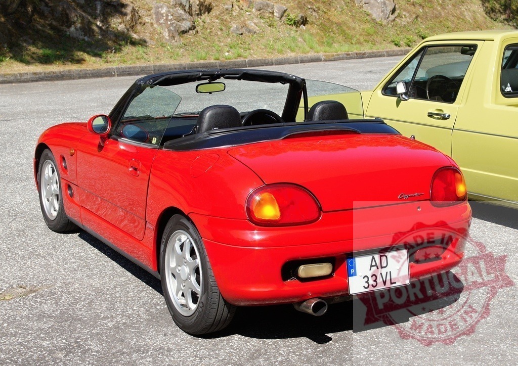 Red Suzuki Cappuccino parked in a parking lot with open roof | Shiny red Suzuki Cappuccino parked in a parking lot enjoying a sunny day - Realized with Pictrs.com