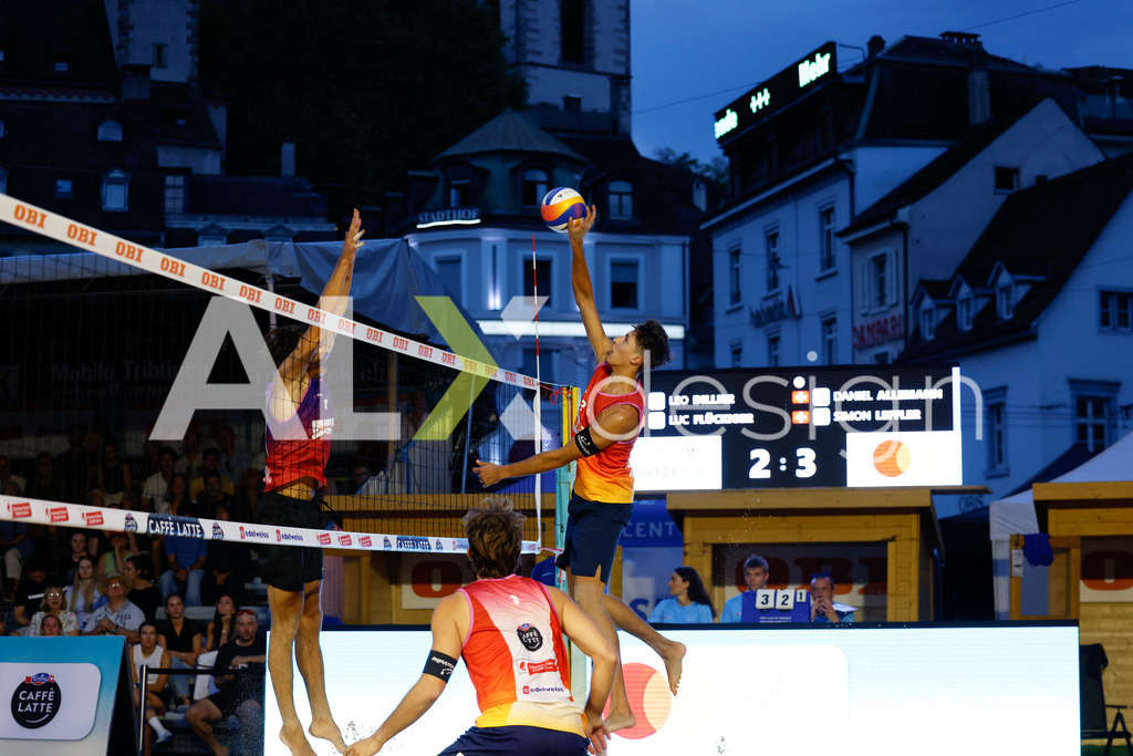 Obi BeachTour 2026 - Basel | BASEL, SWITZERLAND - JULY 17: LUC EMANUEL FLÜCKIGER (SUI) attack / spike against SIMON LEFFLER (SUI) block during the Obi BeachTour 2026 match between DILLIER / FLÜCKIGER (SUI) and ALLEMANN / LEFFLER (SUI) at Barfüsserplatz on July 17, 2026 in Basel, Switzerland. - Realisiert mit Pictrs.com