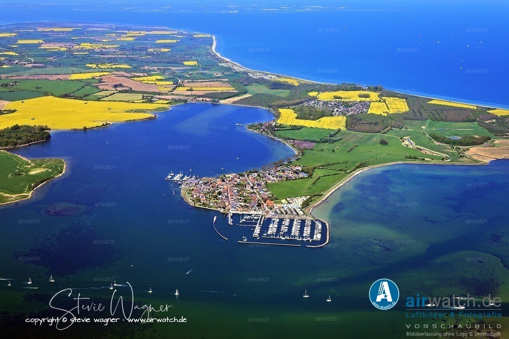Luftbilder Ostseefjord Schlei, Maasholm, Port Olpenitz, Schleimünde | Daraufhin stellte sich die Bevölkerung stark auf die Fischerei um, die bis heute den Ort prägt. Die Fischerei wurde durch die Einführung der Bundgarnfischerei in den 1860er Jahren weiter gefördert, die eine kostengünstige und effektive Methode für den Heringsfang war. Die Holmer Fischerzunft, die 1765 gegründet wurde, vertrat die Interessen der Fischer und setzte sich für nachhaltiges Fischereimanagement ein, etwa durch Schonzeiten und die Rückgabe junger Fische. Heute besteht die Fischerzunft aus nur noch zehn Berufsfischern, darunter die Familie Ross, die seit 1734 auf dem Holm fischt.