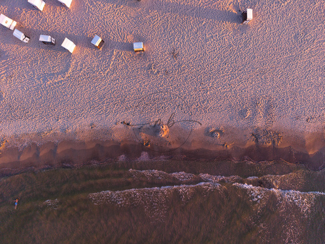 2026-08-08_20-28-16_000 | Luftaufnahme eines sandigen Strandes mit leichten Wellen und verstreuten Strandkörben im Abendlicht, Zempin, Usedom, Mecklenburg-Vorpommern, Deutschland - Realisiert mit Pictrs.com