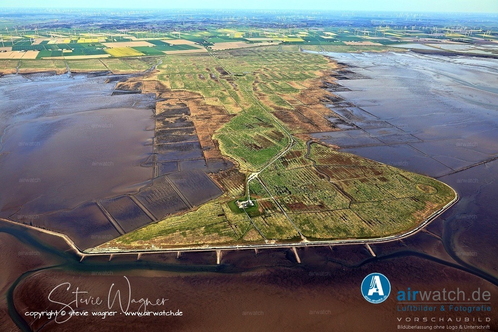 Bis zu 60 Mal im Jahr ist „Land unter" auf der Hamburger Hallig - Luftbild | Ein besonderes Merkmal: Bis zu 60 Mal im Jahr ist „Land unter" auf der Hallig – dann werden Halligvorland und der Zufahrtsweg vom Wasser überflutet.  Dies kann bei Springtide oder Sturmflut auch im Sommer vorkommen. Der dann gesperrte Damm und das Vorland dürfen auf keinen Fall betreten werden. Ein Sturmflutpfahl an der Hauptwarft dokumentiert die höchsten Wasserstände seit 1362.