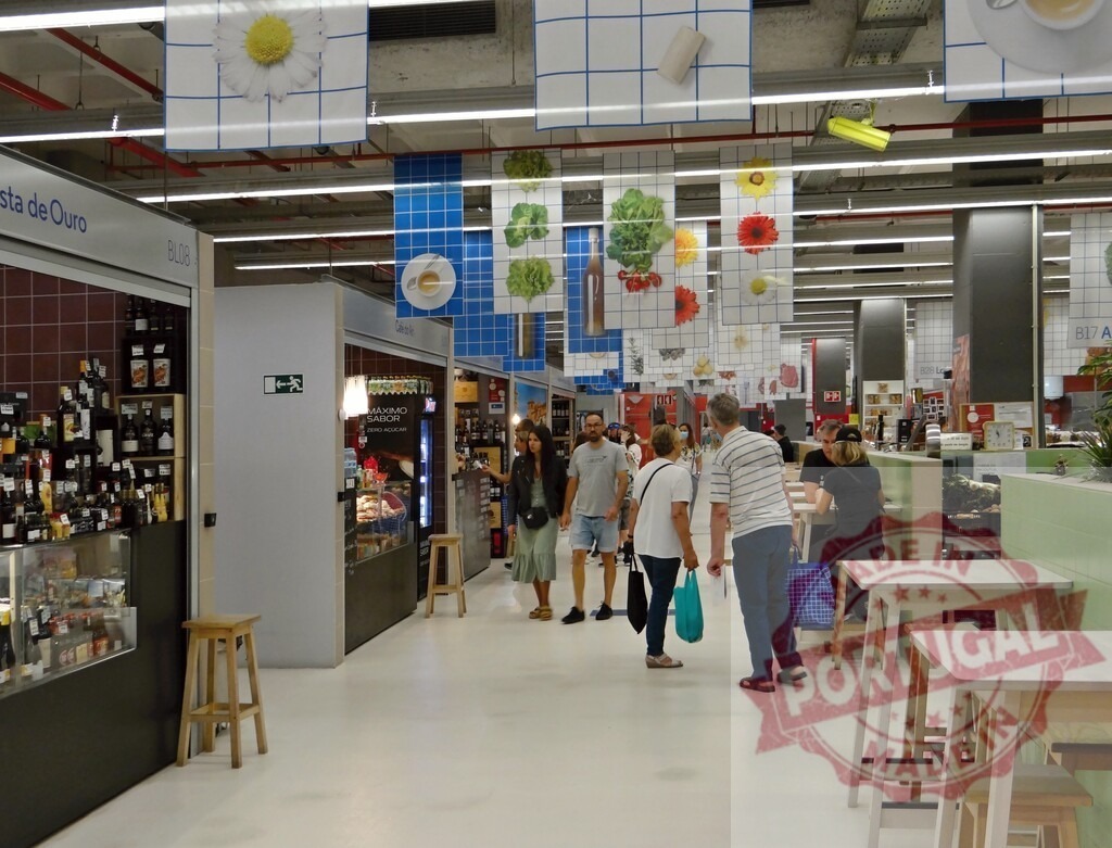 People shopping walking through Lisbon marketplace food court | People enjoying market stalls, dining areas, and diverse food product displays in a modern indoor food market - Realisiert mit Pictrs.com