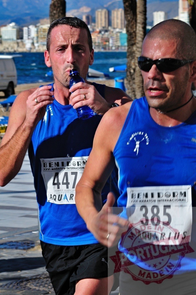 Marathon runners drinking water and running in Benidorm | Two marathon runners drinking water and running near the beach in Benidorm - Realized with Pictrs.com