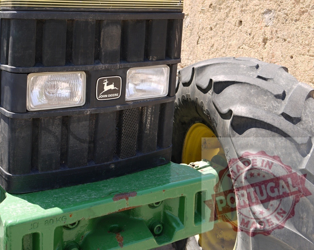 John Deere tractor grill headlights and tire | John Deere tractor grill, headlights, and tire detail on a sunny day - Realized with Pictrs.com