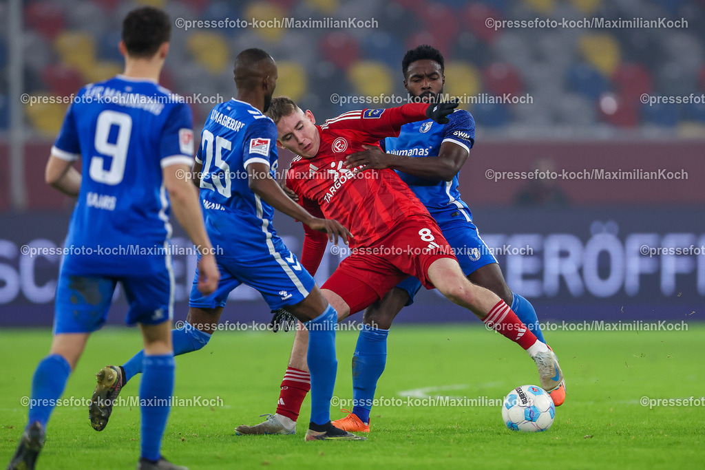 Due20122401077 | 20.12.2024, Fußball, Fortuna Düsseldorf - 1. FC Magdeburg, 2. Bundesliga, Merkur Spiel-Arena, Saison 2024 2025: Silas Gnaka (1.FC Magdeburg #25) und Daniel Heber (1.FC Magdeburg #15) im Zweikampf gegen Isak Johannesson (Fortuna Düsseldorf #8)DFB regulations prohibit any use of photographs as image sequences and or quasi-video.