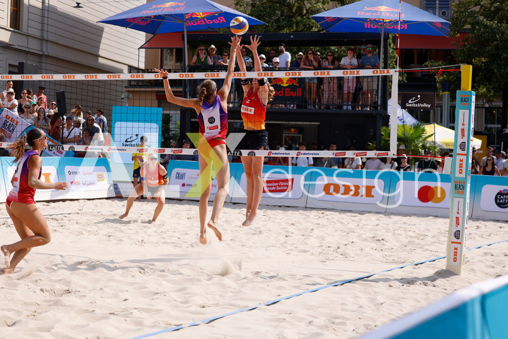 Obi BeachTour 2026 - Basel | BASEL, SWITZERLAND - JULY 19: NADINE DEMIERRE (SUI) attack / spike against LINDA ABBÜHL (SUI) block during the Obi BeachTour 2026 match between BOSSART / ABBÜHL (SUI) and FLÜCKIGER / DEMIERRE (SUI) at Barfüsserplatz on July 19, 2026 in Basel, Switzerland. - Realisiert mit Pictrs.com