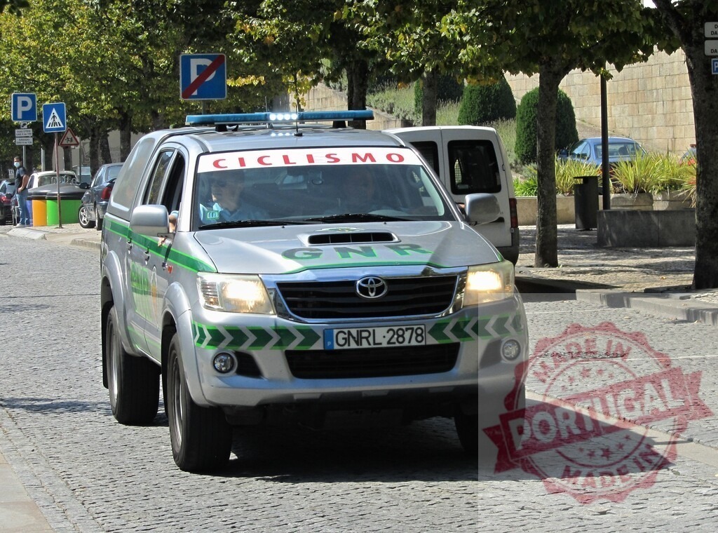 GNR patrol vehicle driving on cobblestone street in Portugal | GNR Guarda Nacional Republicana Toyota Hilux patrolling a street with Ciclismo sign - Realisiert mit Pictrs.com