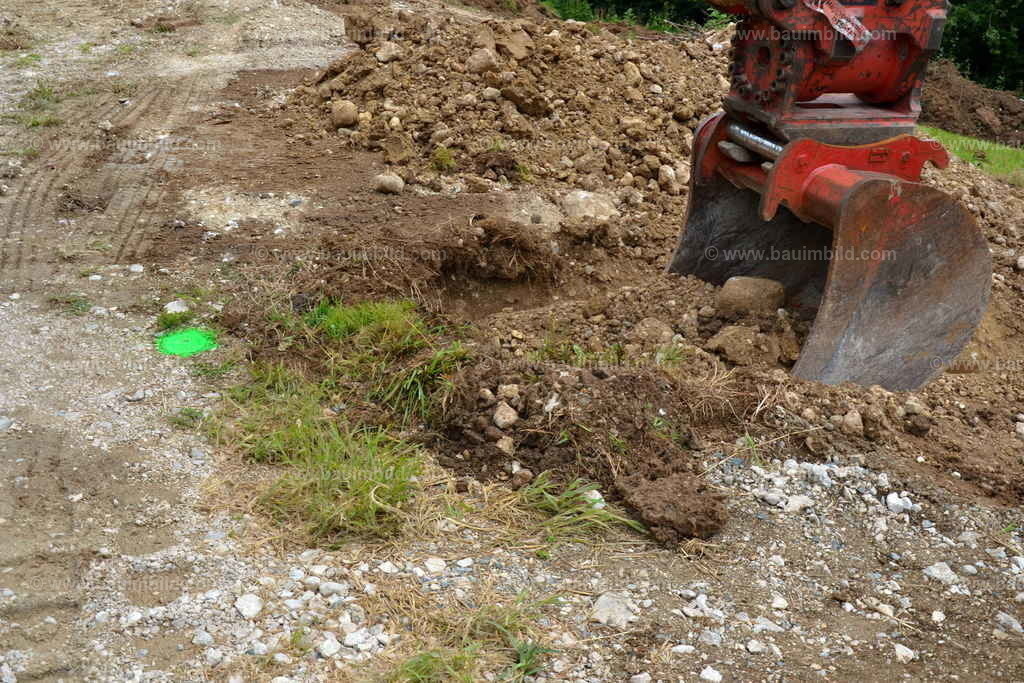 Aushubarbeiten, Grabenaushub | Aushub mit Baggerlöffel in Schotterboden, Grabarbeiten bei markierten Einbauten