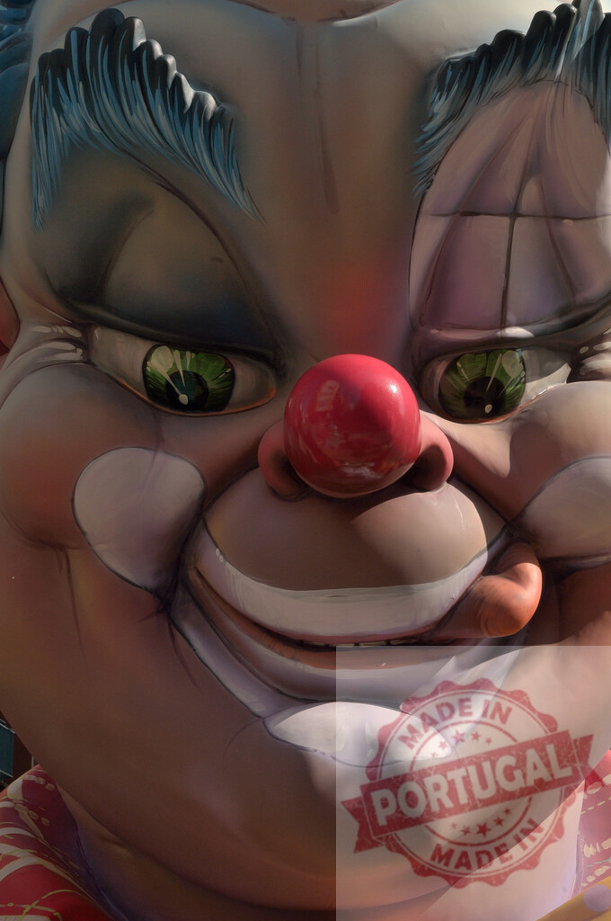 Close up of a big colorful carnival clown face. Fallas Fiestas Communidad Valenciana | Large decorative clown head sculpture with a red nose and green eyes - Realisiert mit Pictrs.com