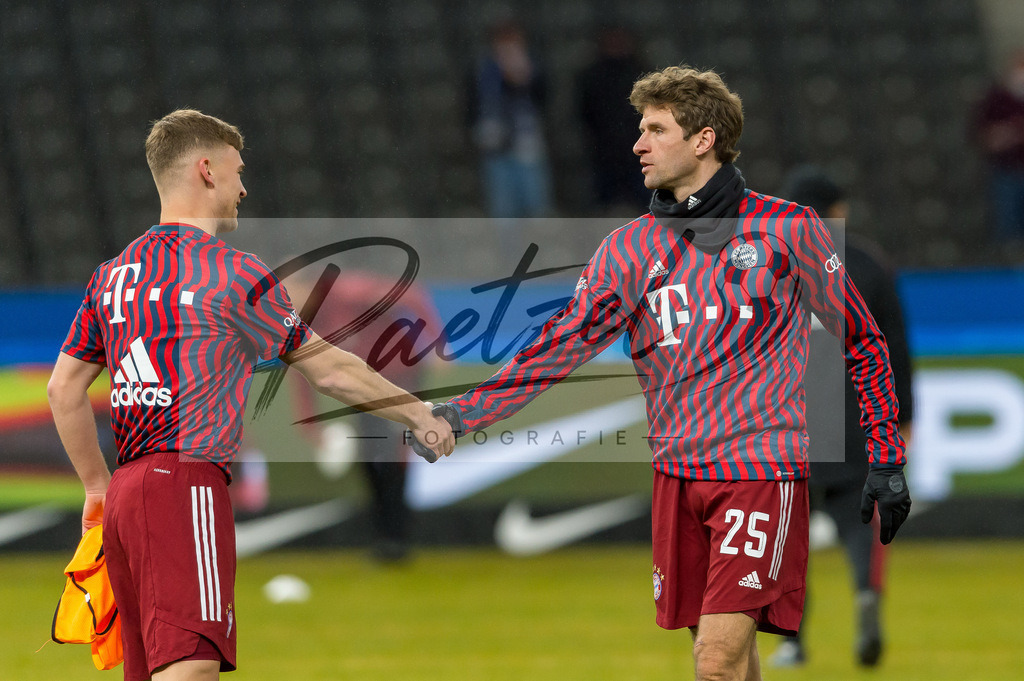 BSCFCB20220123_202 | Fussball, Herren: Joshua Kimmich (FC Bayern Muenchen) und Thomas Mueller (FC Bayern Muenchen) geben sich die Hand bei dem Spiel der 1. Bundesliga zwischen Hertha BSC und FC Bayern Muenchen im Olypiastadion am 23.01.2022 in Berlin, Deutschland.DFB / DFL REGULATIONS PROHIBIT ANY USE OF PHOTOGRAPHS AS IMAGE SEQUENCES AND/OR QUASI-VIDEO. - Realisiert mit Pictrs.com