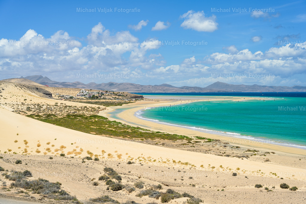 Playa de Sotavento de Jandia auf Fuerteventura | Am Playa de Sotavento de Jandía liegt am Nachmittag strahlender Sonnenschein über der gesamten Küste. Das Meer schimmert in tiefem Türkis und kräftigen Blautönen, die Lagune leuchtet hell und klar. Der breite Sand zieht sich weit durch die Landschaft und reflektiert das warme Licht. Ein Moment, in dem Farbe, Weite und Ruhe zusammenkommen und Sotavento seine ganze Intensität zeigt. - Realisiert mit Pictrs.com