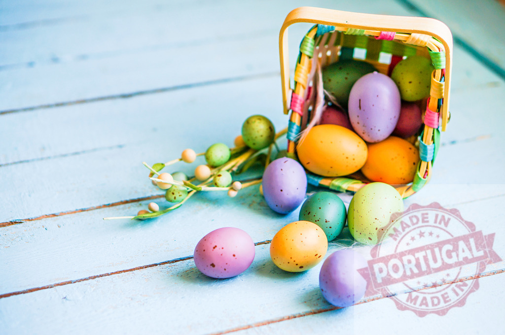 Colorful Easter eggs spilling from basket on blue wood | Colorful speckled Easter eggs scattering from a wicker basket on a rustic blue wooden surface - Realisiert mit Pictrs.com