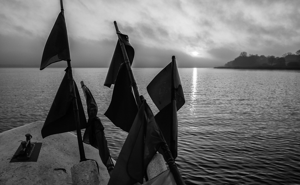 fischer-2019-493 | Matthias Nanz aus Schleswig ist einer der letzten Berufsfischer an der Schlei. Mit seinem Boot, vollgepackt mit Fanggeräten und Netzmarkierungen, fährt Matthias Nanz vom Liegeplatz in Missunde zu den Fanggründen in der Schlei. Das Bild entstand am frühen Morgen Mitte November auf der Großen Breite der Schlei. - Realisiert mit Pictrs.com