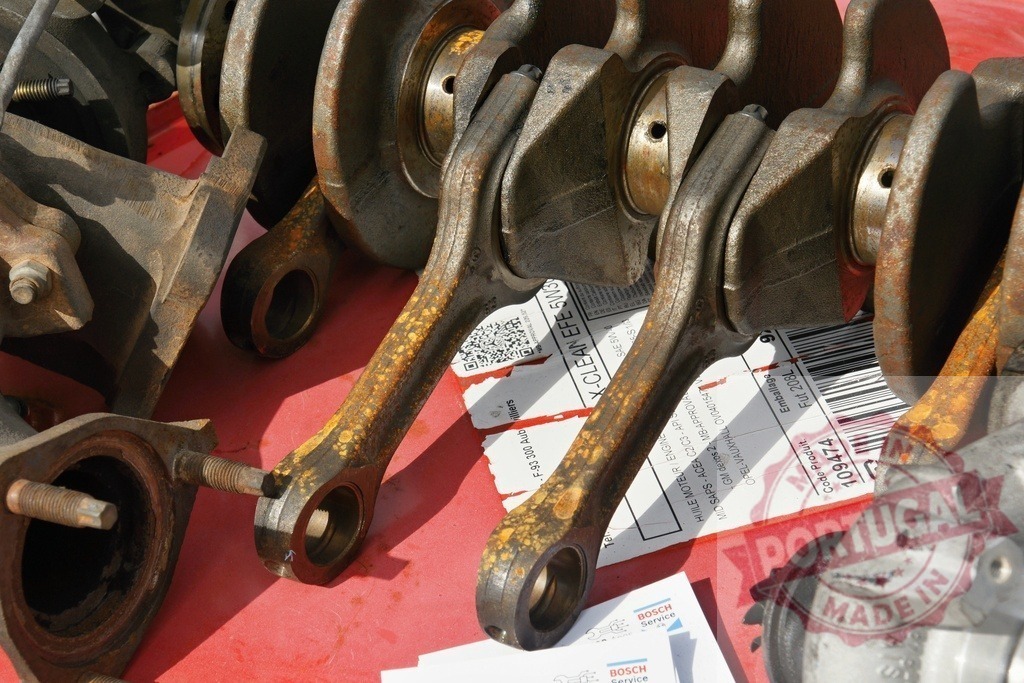 Rusted crankshaft connecting rods and engine parts | Engine parts with crankshaft connecting rods showing rust and wear, needing repair - Realized with Pictrs.com