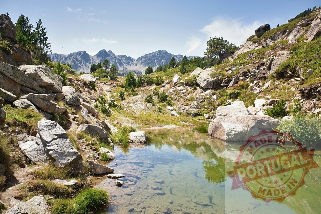 Mountain lake reflecting rocky peaks in Pyrenees | Clear mountain lake reflecting the surrounding rocky slopes and distant peaks under blue sky - Realized with Pictrs.com