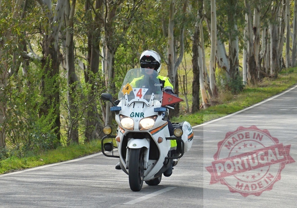 GNR police officer riding motorcycle on forest road | GNR motorcycle officer patrolling a winding road through a forest - Realisiert mit Pictrs.com