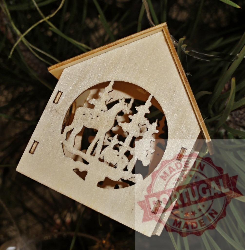 Wooden christmas ornament depicting reindeer and fir trees hanging on christmas tree | Christmas decoration representing a reindeer and fir trees cut out of wood, hanging on a natural christmas tree - Realized with Pictrs.com