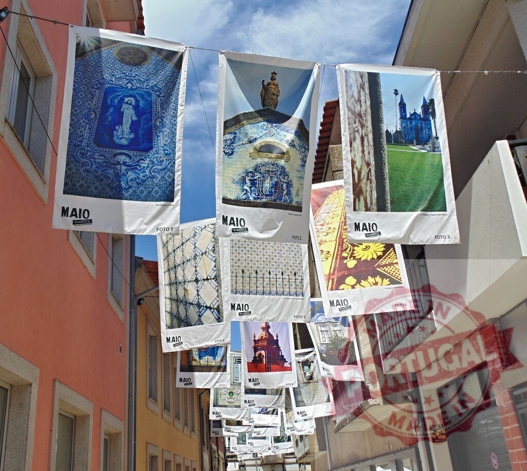 Maio photography exhibition banners decorating street in Portugal. Aveiro - Portugal | Photography exhibition banners featuring Azulejos and Portuguese architecture hanging across a street - Realisiert mit Pictrs.com