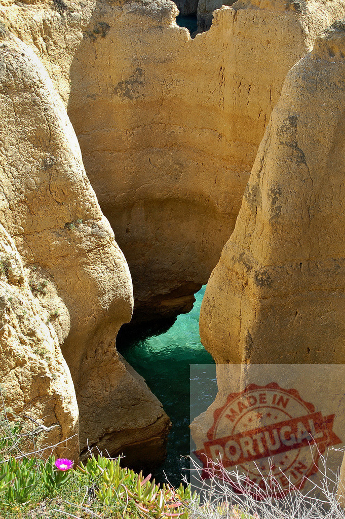 Algarve coastline with turquoise ocean water between eroding cliffs | Eroding cliffs and rock formations revealing clear turquoise ocean water in the Algarve - Realized with Pictrs.com
