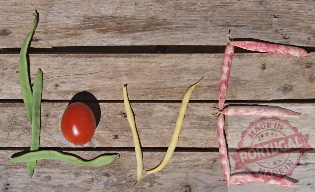 Creating the word love with fresh garden vegetables | Fresh beans and a tomato forming the word love on rustic wooden planks - Realisiert mit Pictrs.com
