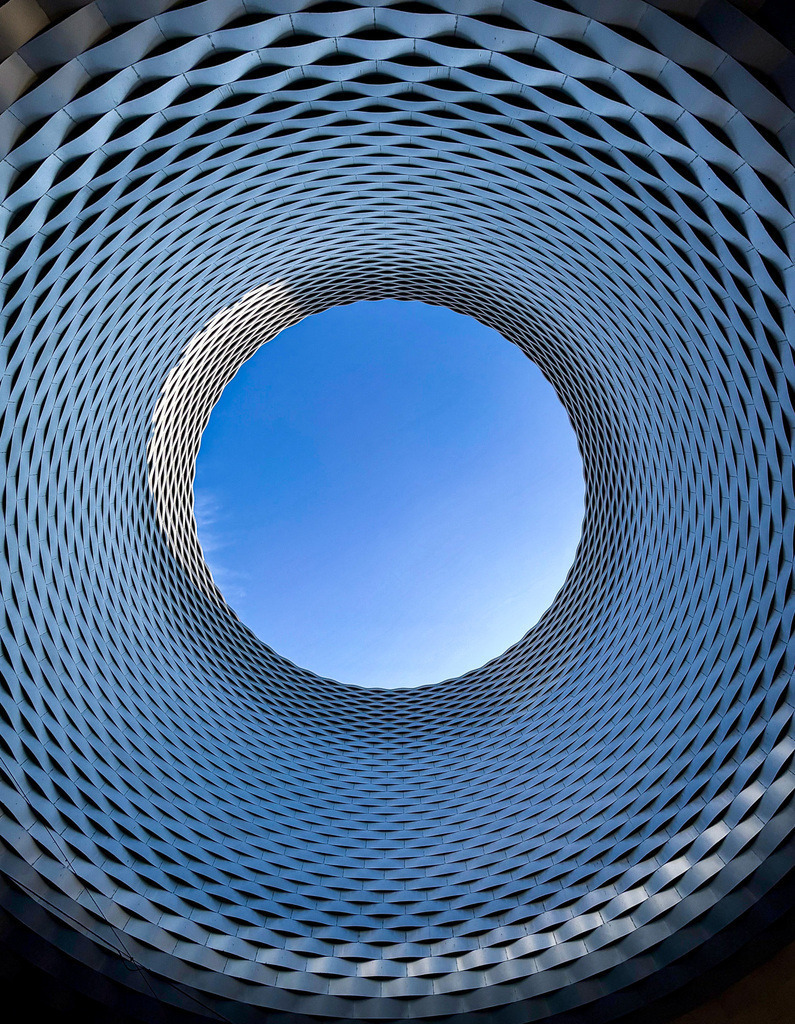 Celestial Geometry | Beschreibung:A circular architectural structure opening into the sky, blending geometry, symmetry and futuristic design into a celestial urban composition. - Realisiert mit Pictrs.com