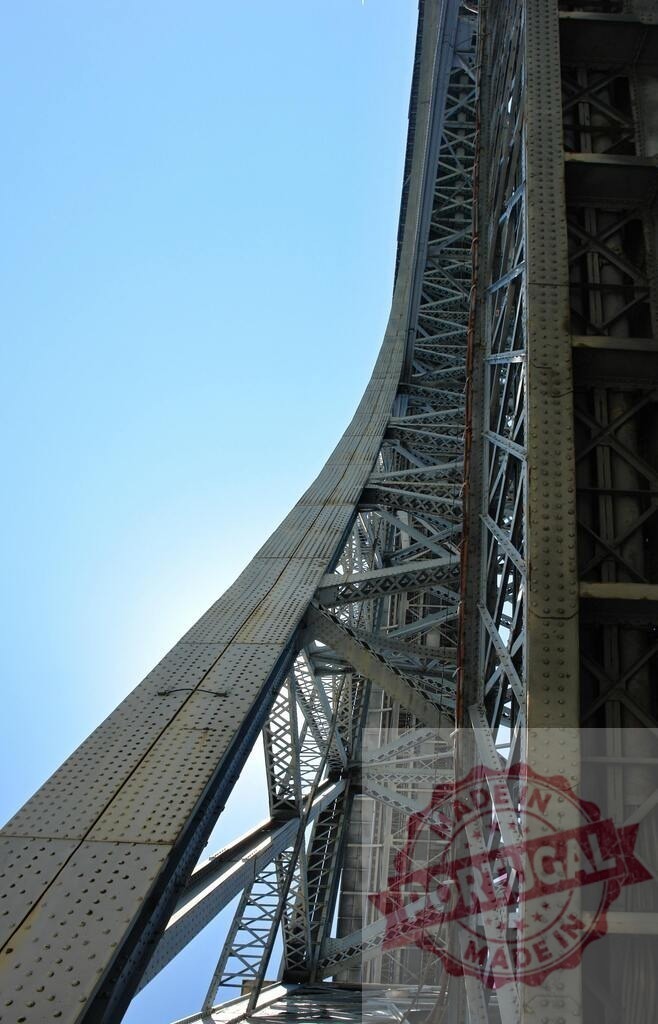 Dom Luís I Bridge iron structure against clear sky | Dom Luís I Bridge showing detailed iron lattice and arch construction against a bright blue sky - Realized with Pictrs.com