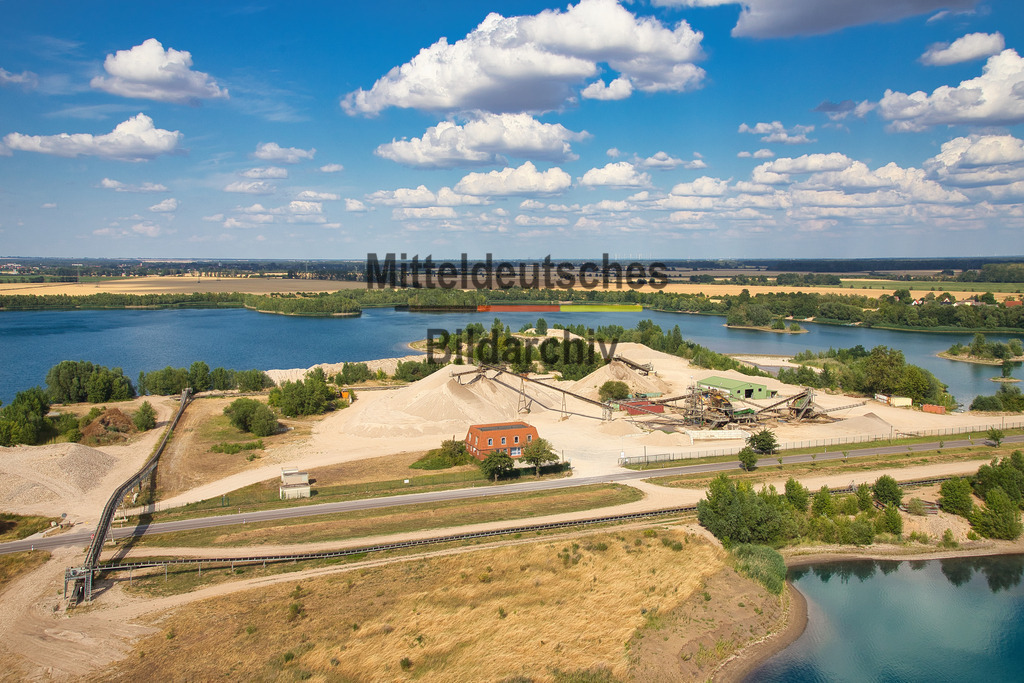 Kieswerk_Hülskens_Tornitz_1985 | Die Kieswerke der Hülskens Barleben GmbH &amp; Co. KG in Rothensee bei Magdeburg sowie in Tornitz und Barby gehören zu den bedeutenden Standorten der Kies- und Sandgewinnung in Sachsen-Anhalt. Die Luftaufnahmen aus der Perspektive des Tragschraubers zeigen die weitläufigen Abbauflächen mit ihren großen Kiesseen, modernen Förder- und Aufbereitungsanlagen sowie der leistungsfähigen Betriebstechnik. Aus der Vogelperspektive werden die Dimensionen der Rohstoffgewinnung und die enge Verbindung von Gewinnung, Aufbereitung und Rekultivierung eindrucksvoll sichtbar.
 - Realisiert mit Pictrs.com