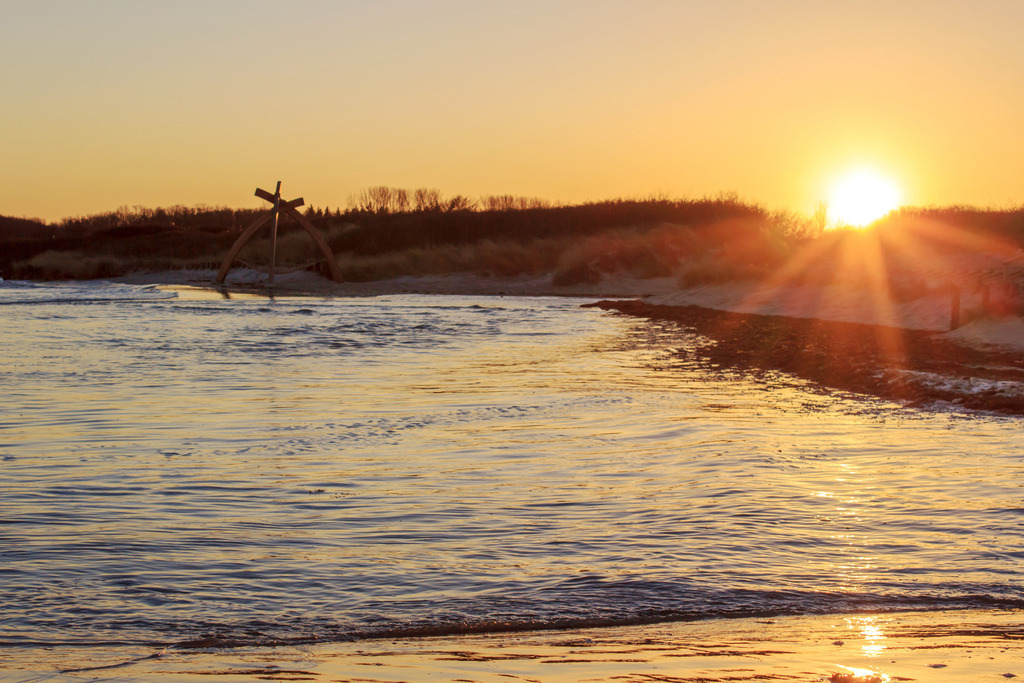 Wandbild: Sonnenuntergang an der Ostsee | Dieses Wandbild zeigt Hochwasser am Ostseestrand. Dadurch konnte dieser malerischer Sonnenuntergang an der Ostsee festgehalten werden. Die Sonnenstrahlen sind gut zu erkennen. Das Licht der untergehenden Sonne scheint auf den Sandstrand. - Realisiert mit Pictrs.com