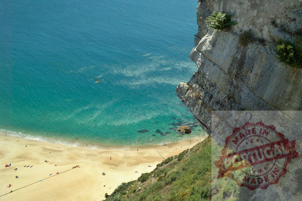 High angle view of turquoise ocean beach cliff | Turquoise ocean meeting a sandy beach with people and a steep cliff - Realisiert mit Pictrs.com