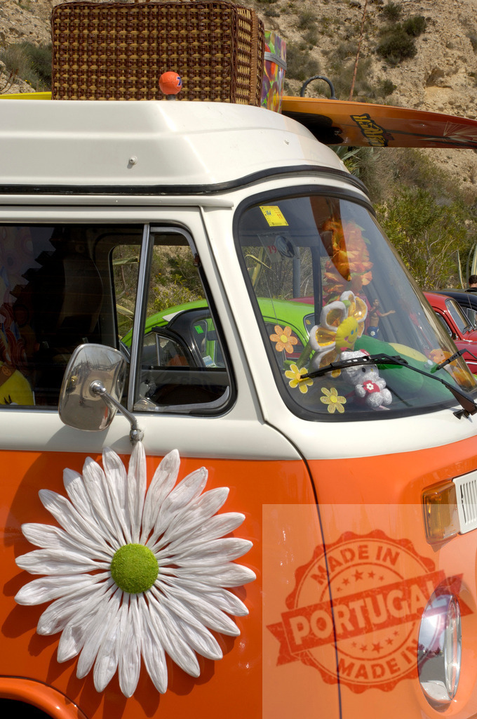 Orange Volkswagen van decorated with retro flower power stickers | Vintage VW bus featuring hippie-style decorations including a large daisy decal and flower ornaments - Realisiert mit Pictrs.com