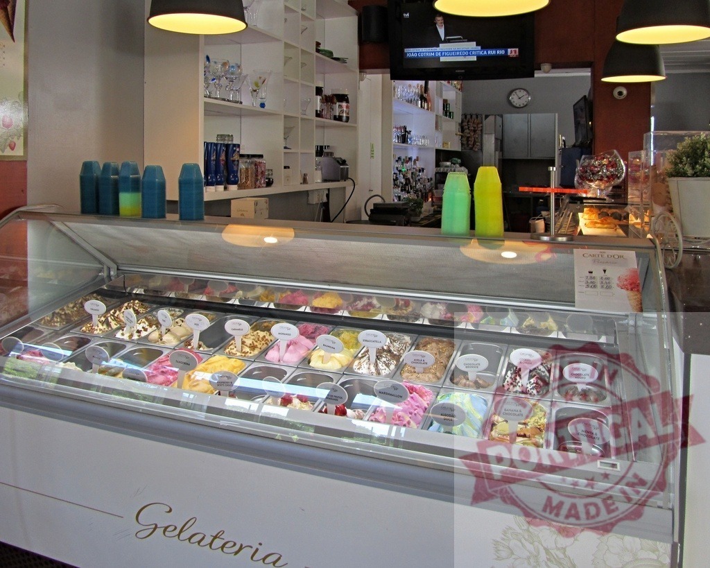 Gelateria display case offering variety of delicious gelato flavors | Gelateria display case presenting many flavors of ice cream and sorbet - Realisiert mit Pictrs.com