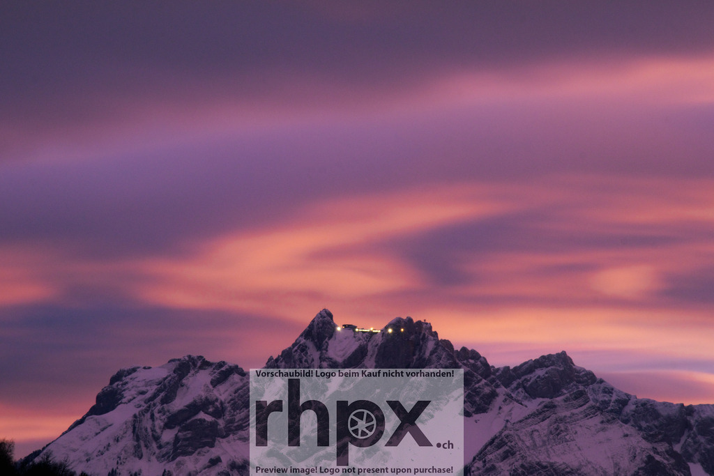 Abendhimmel über dem Pilatus | Gipfel. Licht. Magie. Ein spektakuläres Farbspiel aus sanftem Violett und Rosa umhüllt den schneebedeckten Hausberg Pilatus von Luzern. Die Lichter der Bergstation funkeln wie Sterne in der Dämmerung und krönen dieses majestätische Alpenpanorama. Wähle unter "Produktauswahl" dein Wunschformat: Vom klassischen Wandbild über Puzzle &amp; Tassen bis zum digitalen Download (z.B. als Handy-Hintergrund). - Realisiert mit Pictrs.com